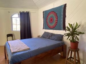 a bedroom with a bed with a quilt hanging on the wall at Colibri Paradise in Cahuita