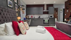 a living room with a large bed with red and white pillows at Victoria Loft - 1 Bedroom Apartment with off site spa access in Bowness-on-Windermere