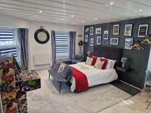 a bedroom with a bed and a chair and a clock at Victoria Loft - 1 Bedroom Apartment with off site spa access in Bowness-on-Windermere