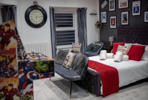 a bedroom with a bed and a clock on the wall at Victoria Loft - 1 Bedroom Apartment with off site spa access in Bowness-on-Windermere +51 photos
