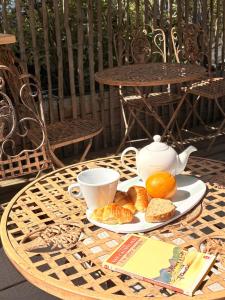 a table with a tea pot and a plate of croissants at Fleur de Ré in Loix