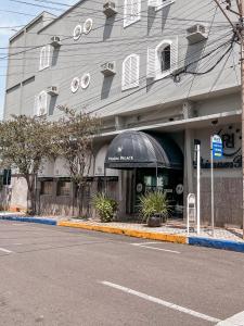 a building with an awning on the side of a street at Primum Palace Hotel in Dracena
