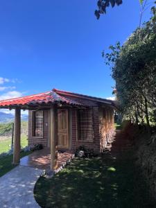 a log cabin with a porch and a driveway at Refugio del venado familiar in Cotacachi