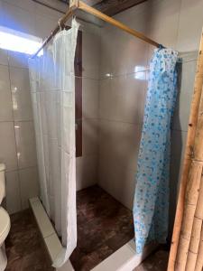 a shower with a blue shower curtain in a bathroom at Refugio del venado familiar in Cotacachi