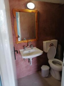 a bathroom with a sink and a toilet and a mirror at Armonia Studios in Agios Georgios +117 photos