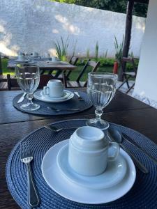 a table with a white plate and glasses on it at Pousada Viva Paraíso in Alto Paraíso de Goiás