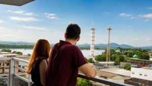 a man and a woman standing on a balcony overlooking a city at Barrudada Palace Hotel-Boa Vista in Boa Vista