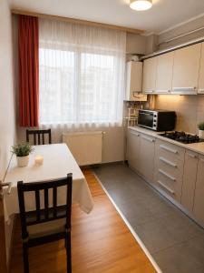 a kitchen with a table and a stove top oven at King Apartment Bucharest in Dudu