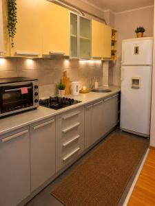 a kitchen with white appliances and a white refrigerator at King Apartment Bucharest in Dudu