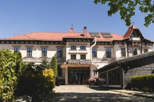 a large building with a hotel sign in front of it at Hotel Carol - Vatra Dornei in Vatra Dornei
