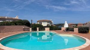 a swimming pool with blue water in front of a house at Yacht Terrace - Exclusive Waterfront View Porto Cervo Center - by Coral Property in Porto Cervo