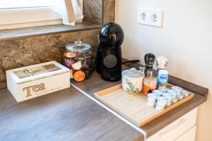 a kitchen counter with a coffee maker and a cutting board at Róna Fénye Vendégház in Sándorfalva