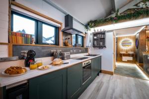 a kitchen with green cabinets and some food on the counter at Queen's Loft in Windermere