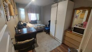 a room with a desk and a bedroom with a bed at Cosy room in Oslo