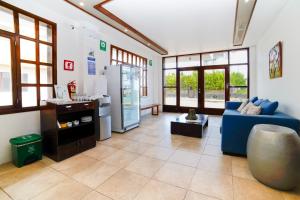 a living room with a blue couch and a refrigerator at Hotel Volcano in Puerto Villamil