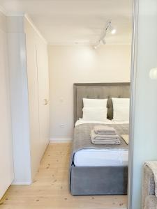 a small bedroom with a bed and a mirror at Det Gamle Vaskeri - Historical Apartment in Horsens in Horsens
