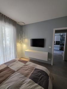 a bedroom with a large bed and a flat screen tv at Casa Alma in Lido di Fermo