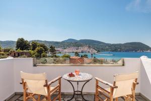 a table and chairs on a balcony with a view of the water at Marani Villas Collection in Skopelos Town