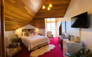 a bedroom with a bed and a flat screen tv at Hanlon Guest House in Stanley