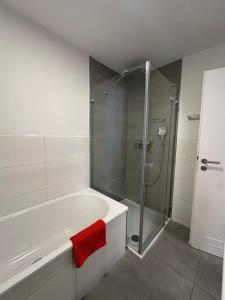 a bathroom with a shower and a bath tub with a red towel at SWISS LOFT by Europa-Park - EP Ticket Garantie in Rust +39 photos