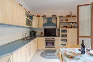 a kitchen with wooden cabinets and a table with a tablecloth at Lenno Glamour in Lenno +18 photos