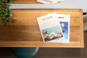 two magazines sitting on a wooden table at Studio Apartment 5, Unique Location - Sea View in Lithakia +30 photos