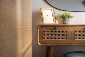 a wooden side table with a picture and a plant on it at Studio Apartment 5, Unique Location - Sea View in Lithakia