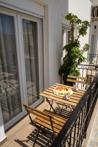 a wooden table with a bowl of fruit on a balcony at Cerro Fine Living in Ermoupoli