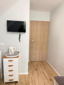 a room with a door with a television on the wall at Pokoje przy rzece in Supraśl