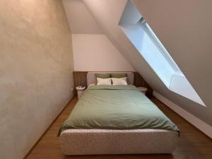 a bed in a small room with a roof at Apartmány u čalouníků in Litomyšl