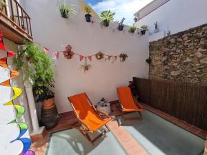 Zwei orangefarbene Stühle stehen auf einer Terrasse mit Pflanzen. in der Unterkunft Ca la Babus in Bellcaire dʼEmpordà