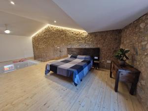 ein Schlafzimmer mit einem Bett in einer Steinwand in der Unterkunft Ca la Babus in Bellcaire dʼEmpordà + 12 Fotos