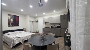 a bedroom with a bed and a table and a kitchen at B&B Lamezia Terme Centro in Lamezia Terme