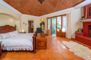 a bedroom with a large bed and a fireplace at La Sagrada in Guanajuato