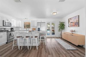 a kitchen with white cabinets and a table and chairs at Teal We Meet Again - Team Joseph Ellen in Jacksonville Beach