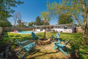 a yard with three blue chairs and a fire pit at Teal We Meet Again - Team Joseph Ellen in Jacksonville Beach