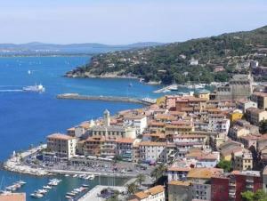 a city with a harbor and boats in the water at Casa Cavour 15 in Porto Santo Stefano