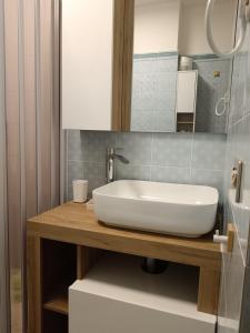 a bathroom with a white sink on a wooden counter at Casa Cavour 15 in Porto Santo Stefano +10 photos