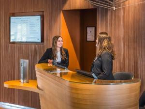 two women sitting at a counter in a room at Mercure Dijon Centre Clemenceau in Dijon