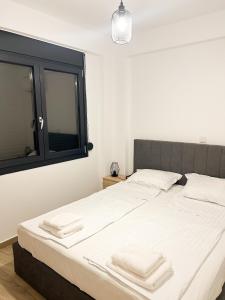 a bedroom with a bed with two towels on it at Sea Shell Apartment - Paralia Ofriniou, Swimming pool, Starlink WIFI in Orfánion