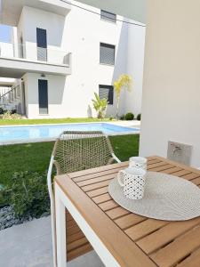 a wooden table with a coffee cup on top of it at Sea Shell Apartment - Paralia Ofriniou, Swimming pool, Starlink WIFI in Orfánion