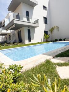 a villa with a swimming pool in front of a building at Sea Shell Apartment - Paralia Ofriniou, Swimming pool, Starlink WIFI in Orfánion +14 photos