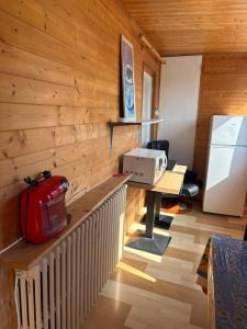 a kitchen with a counter with a microwave and a refrigerator at La Cheminée - Chambres Gîtes Appartements et Mobile Homes avec Bar-Restaurant in Tardets-Sorholus