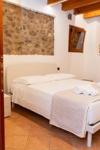 a bedroom with two beds and a stone wall at Gomes Comfort House Borghetto in Valeggio sul Mincio
