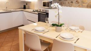 a kitchen with a table with plates and glasses on it at Gomes Comfort House Borghetto in Valeggio sul Mincio +32 photos