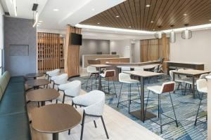 a waiting room with tables and chairs at SpringHill Suites by Marriott Atlanta Covington in Covington