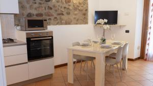 a kitchen with a table with chairs and a microwave at Gomes Comfort House Borghetto in Valeggio sul Mincio