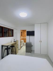 a kitchen with white cabinets and a desk and a table at Ruka Manor B&B in Strand