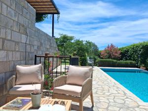 a patio with two chairs next to a swimming pool at Villa Casa Belvedere near Dubrovnik in Gruda