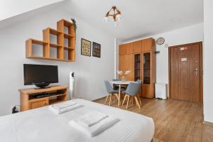a bedroom with a bed and a tv and a table at Lublin Old Town Studio by BookingHost in Lublin